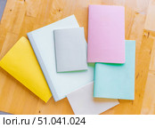 Beautiful notebooks or notebooks for studying or writing in beautiful pastel shades, for school, universities or working on a wooden surface that creates a warm and cozy background. Стоковое фото, фотограф Анастасия Мерчик / Фотобанк Лори