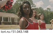 A group of high school cheerleaders in red uniforms perform a synchronized routine in a suburban area on a bright day. Стоковое AI-видео, аниматор Данила Большаков / Фотобанк Лори