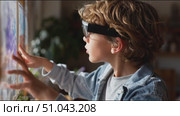 Child interacts with augmented reality display while exploring learning concepts at home during afternoon. Стоковое AI-видео, аниматор Сергей Толмачёв / Фотобанк Лори