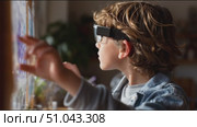 Young boy explores augmented reality technology in innovative learning environment. Стоковое AI-видео, аниматор Сергей Толмачёв / Фотобанк Лори