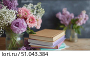 Colorful flowers and stacked books create a cozy study atmosphere in a well-lit room during springtime. Стоковое AI-видео, аниматор Сергей Толмачёв / Фотобанк Лори