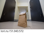 An eco paper bag is standing in the lobby on the doorstep of the apartment. Contactless food delivery to the epidemic. The courier left an online order at the entrance. precautionary measures. Стоковое фото, фотограф Михаил Решетников / Фотобанк Лори
