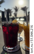Освежающие напитки на террасе у бассейна на закате Colorful tropical cocktails on wooden tray by luxury resort swimming pool with ocean view. Refreshing mojito, daiquiri, and fruit beverages garnished with mint leaves and orange slices. Paradise. Стоковое видео, видеограф Zita Khasanova / Фотобанк Лори