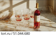 Beautiful setup of rose wine and elegant glasses on a marble countertop in soft afternoon light. Стоковое AI-видео, аниматор Сергей Толмачёв / Фотобанк Лори
