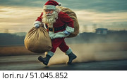 A man dressed as Santa Claus runs energetically across an open landscape, carrying a large sack of gifts as the sun sets. Стоковое AI-видео, аниматор Данила Большаков / Фотобанк Лори