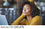 A young woman in a yellow sweater and beret concentrates deeply as she works at her desk, surrounded by stacks of documents and a laptop. Стоковое AI-видео, аниматор Данила Большаков / Фотобанк Лори