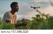 Man controls drone in lush field at sunset capturing stunning aerial views of nature. Стоковое AI-видео, аниматор Сергей Толмачёв / Фотобанк Лори