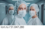 Team of medical professionals in masks and gowns working together. They are focused and determined as they attend to patients. Стоковое AI-видео, аниматор Данила Большаков / Фотобанк Лори