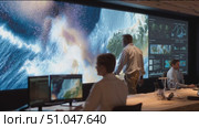 Professionals analyze data at a modern workspace featuring large displays and real-time information systems. Стоковое AI-видео, аниматор Сергей Толмачёв / Фотобанк Лори