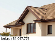 House Exterior. Roof Window. Second floor among blue sky. Mansard attic. Newly build houses. Gable roof with skylight, asphalt roofing, shingles. Residential Home. Vinyl Siding. Polymeric roof-tiles. Стоковое AI-изображение, AI-художник Марина Демидюк / Фотобанк Лори