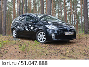 Черный автомобиль Toyota Prius в лесу (2023 год). Редакционное фото, фотограф Николай Кузнецов / Фотобанк Лори