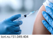 Doctor making a vaccination. Cropped of man receiving vaccine shot. Hands injecting coronavirus vaccine syringe to arm muscle of patient. Covid 19 immunization. Mpox, Dengue fever, Chikungunya. CHIKV. Стоковое AI-изображение, AI-художник Марина Демидюк / Фотобанк Лори