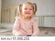 Little Girl joking sticking tongue out with silly expression. Child making face. Funny foolishness portrait of baby girl laughing in bedroom. Adorable Caucasian kid doing crazy comical gesture at home. Стоковое фото, фотограф Марина Демидюк / Фотобанк Лори