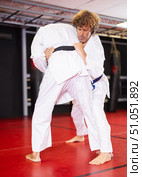 Jiu‑jitsu fighter practicing techniques on red tatami. Стоковое фото, фотограф Яков Филимонов / Фотобанк Лори