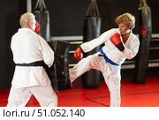 Middle‑aged man practicing kick on shield in karate dojo. Стоковое фото, фотограф Яков Филимонов / Фотобанк Лори