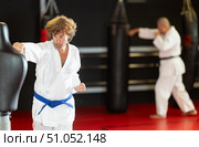 Man in white kimono trains in gym - he punches sports dummy. Стоковое фото, фотограф Яков Филимонов / Фотобанк Лори