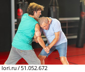 Elderly man learning self-defense grips and escapes at gym. Стоковое фото, фотограф Яков Филимонов / Фотобанк Лори