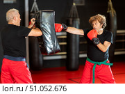 Krav Maga student punching shield during self‑defense drill. Стоковое фото, фотограф Яков Филимонов / Фотобанк Лори