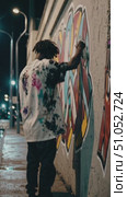 An Urban Artist Expresses Creativity Through Vibrant Graffiti on a Nighttime City Wall, Capturing the Essence of Street Art Culture and Personal Expression. Стоковое AI-видео, аниматор Владимир Федоров / Фотобанк Лори