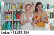 Women friends choose sunscreen in household chemicals store. Стоковое видео, видеограф Яков Филимонов / Фотобанк Лори