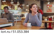 Portrait of young girl with cup in hands drinking coffee in coffee shop indoors. Стоковое видео, видеограф Яков Филимонов / Фотобанк Лори