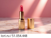 A vibrant pink lipstick rests on a smooth marble surface, catching the faint rays of light that create an elegant atmosphere. The golden casing adds a touch of luxury to the arrangement. Стоковое AI-изображение, AI-художник Ольга Игнашина / Фотобанк Лори