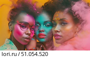 Three charming african american women with varied colored powder on their faces present an engaging and vibrant sight. Стоковое AI-видео, аниматор Данила Большаков / Фотобанк Лори