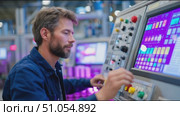 Engineer operates control panel in modern manufacturing facility during daytime. Стоковое AI-видео, аниматор Сергей Толмачёв / Фотобанк Лори