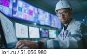 Engineer monitors data and operates equipment in high-tech control room during night shift at research facility. Стоковое AI-видео, аниматор Сергей Толмачёв / Фотобанк Лори