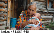 Бабушка в деревне несет малыша. Grandma is carrying a baby in the village. Стоковое AI-изображение, AI-художник Смирнова Светлана / Фотобанк Лори