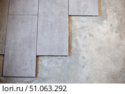 Close-up of large format ceramic tiles being laid on cement screed. Стоковое фото, фотограф Коханова Наталья / Фотобанк Лори
