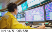 Professional technician monitors complex systems in a control room with multiple screens and active data displays. Стоковое AI-видео, аниматор Сергей Толмачёв / Фотобанк Лори