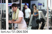 During workout, guy performs grueling exercises and pumps muscles of arm on crossover exercise machine. Sport club client participates in fitness marathon, works with muscles and endurance. Стоковое видео, видеограф Яков Филимонов / Фотобанк Лори