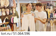 Couple carefully inspected various trousers, comparing styles and sizes, in search of perfect pair. Стоковое видео, видеограф Яков Филимонов / Фотобанк Лори