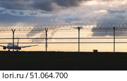 Airplane landing over barbed wire fence at sunset. Стоковое видео, видеограф Mikhail Davidovich / Фотобанк Лори