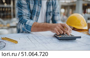 Construction worker drafts building plans while calculating project costs at job site in daylight. Стоковое AI-видео, аниматор Сергей Толмачёв / Фотобанк Лори