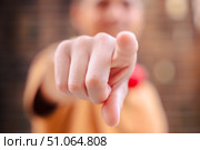 Person pointing directly at camera with blurred face in background. Стоковое фото, фотограф Raquel Corcoles Mendez / Фотобанк Лори