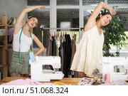 Two young seamstresses doing exercises during break. Стоковое фото, фотограф Яков Филимонов / Фотобанк Лори
