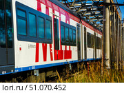 A long train with the inscription "MCD" on board. The train is red and white. Russia. Moscow oblast. 14.08. 2025. Редакционное фото, фотограф Ярославский Максим / Фотобанк Лори