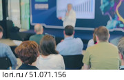 Audience listening to a business speaker at a presentation with a graph display. Стоковое видео, видеограф Антон Гвоздиков / Фотобанк Лори