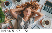 A young woman sleeping peacefully on her bed with a laptop, coffee cups, and books scattered around her. Стоковое AI-видео, аниматор Данила Большаков / Фотобанк Лори