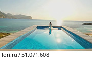 Relaxing view of a serene ocean sunset with a person enjoying the tranquility at a coastal pool. Стоковое AI-видео, аниматор Данила Большаков / Фотобанк Лори