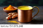 Golden milk with turmeric powder and root in copper mug promoting health and wellness. Стоковое AI-изображение, AI-художник Юрий Поздников / Фотобанк Лори