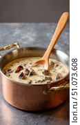 Creamy mushroom soup simmering in copper pot with wooden spoon. Стоковое AI-изображение, AI-художник Юрий Поздников / Фотобанк Лори