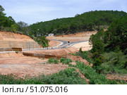 A highway on red-brown soil among green rainforests in Southeastern Vietnam. Стоковое фото, фотограф Сергей Фролов / Фотобанк Лори