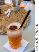 Close-up of a refreshing orange cocktail in a tall glass with a slice of dried citrus. Стоковое фото, фотограф Виктор Ветошкин / Фотобанк Лори