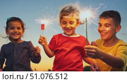 Children enjoy a joyful summer evening with sparklers and laughter during Independence Day festivities. Стоковое AI-видео, аниматор Данила Большаков / Фотобанк Лори