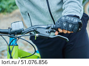 The cyclist's hand is on the handlebars of the bike. Cycling and moving around the city on environmentally friendly transport. Стоковое фото, фотограф Наталия Кирсанова / Фотобанк Лори