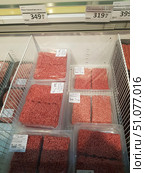 A supermarket refrigerator display case with packaged chilled minced meat. The product is packaged in transparent plastic containers, hermetically sealed in cling film. In the center of the photo are packages of deep pink-red ground beef. Above the display case are price tags: “Ground beef, chilled, packed, kg — 349.99 ₽” and “Homemade ground beef, chilled, packed, kg — 319.99 ₽”. The products are neatly stacked in the metal sections of the refrigerator, ensuring accessibility and order. (2019 год). Редакционное фото, фотограф Анна Кривицкая / Фотобанк Лори