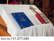 The sacrament of baptism in the Orthodox Church. Prayer books and a crucifix on the table. Inscription on the book: the rite of baptism. Стоковое фото, фотограф Екатерина Красникова / Фотобанк Лори